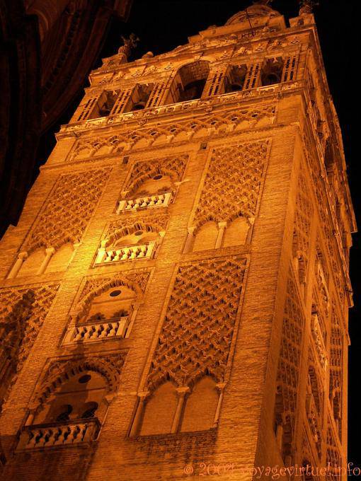 Primer plano de la Giralda iluminada por la noche, la catedral de Sevilla - España