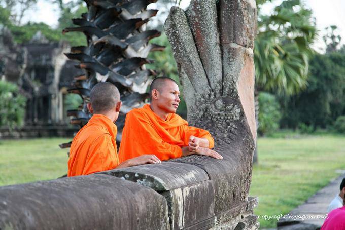 El soñar despierto monjes en una rampa naga-off, Angkor Wat, Angkor, Camboya