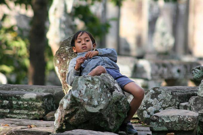 Niño sentado Bayon Angkor Thom, Angkor, Camboya
