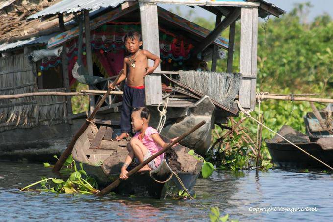 Los niños de maniobrar, el lago Tonle Sap - Camboya
