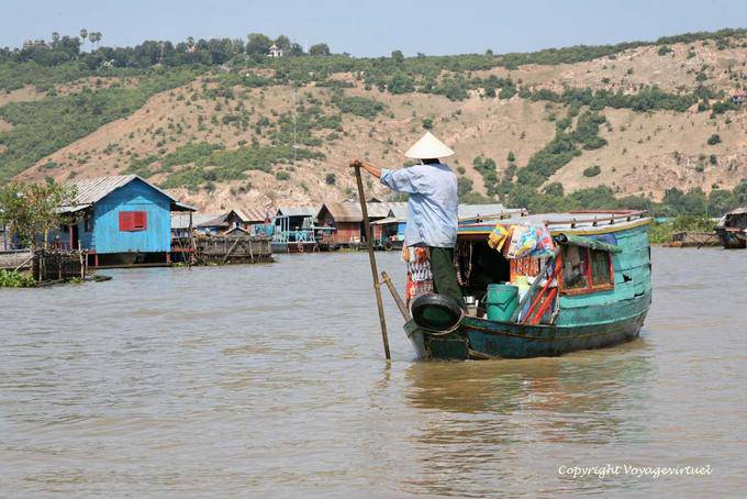 Flotante comerciante de llegar a un pueblo sobre pilotes, Tonle Sap - Camboya