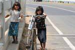 Gamines bicicleta al puente de Kampong Cham Krong, Camboya.
