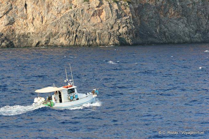 Pesca barco navegando a lo largo de un acantilado Hora Sfakion - Creta, Grecia