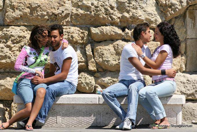 Los amantes que SMOOCH en los bancos públicos, Iráklio (Heraklion) - Creta, Grecia