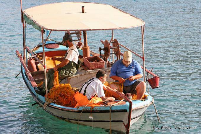 Matala, los pescadores trabajan en su frágil embarcación - Creta, Grecia