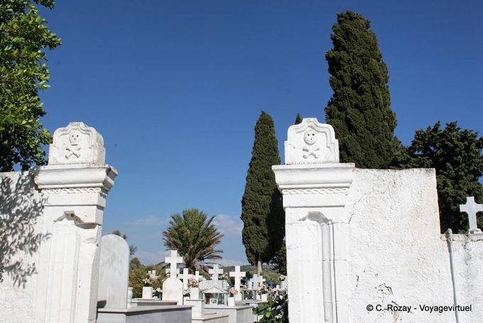 Cráneos en la entrada italiana del cementerio, Vori - Creta, Grecia