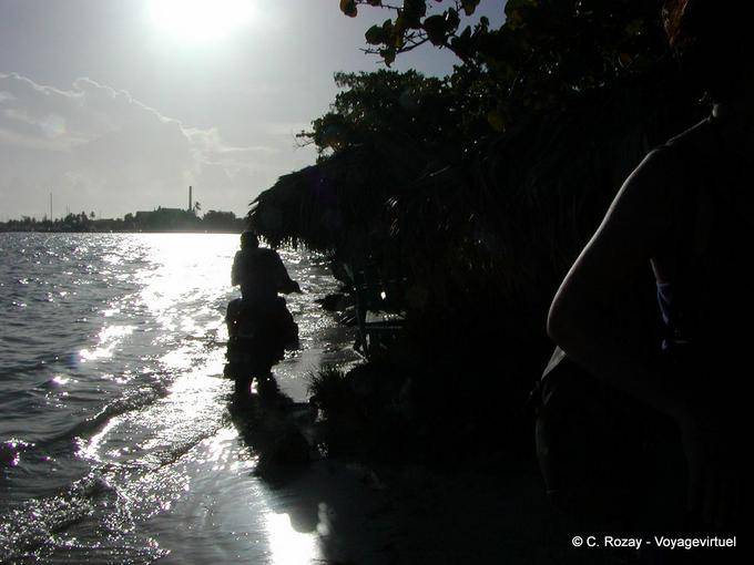 Contra la luz, motocicleta que pasa sobre las olas, Boca Chica, Rep. Dominicana