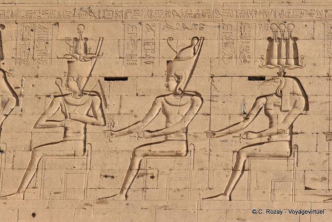 Las representaciones de deidades sentados lado de la torre, el templo de Edfu - Egipto
