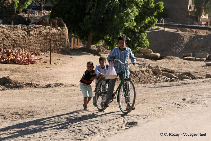 Tres niños con una bicicleta, Luxor - Egipto