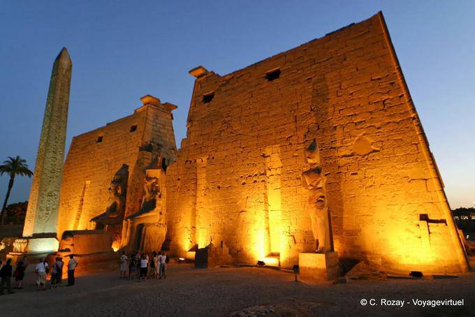 El pilón de Ramsés II, y staues obelisco colosal iluminación vista de noche, Luxor - Egipto