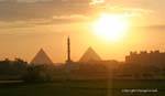 Fabuloso atardecer sobre las pirámides que flanquean el minarete de una mezquita de El Cairo, Egipto.