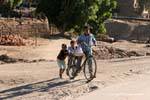 Tres niños con una bicicleta, Luxor, Egipto.