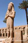 Alta estatua de Ramsés II, con su hija y novia real en sus pies, Karnak, Egipto.