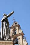 Estatua católica frente a las cigüeñas campanario, Salamanca, España.