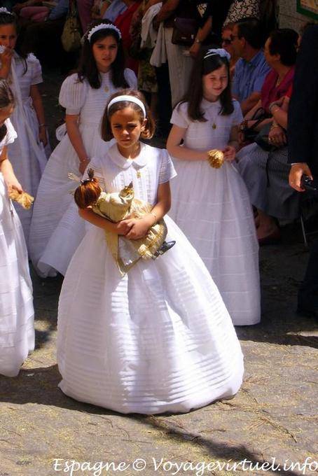 Chica con vestido blanco con una procesión muñeca en Toledo - España