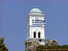 Bandera griega y el campanario, Poros, Grecia.