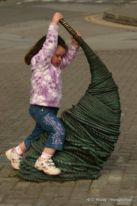 Niña que juega en una escultura, Dingle - Irlanda