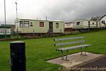 Banco y casas móviles en el cielo gris, Bundoran Donegal, Irlanda.