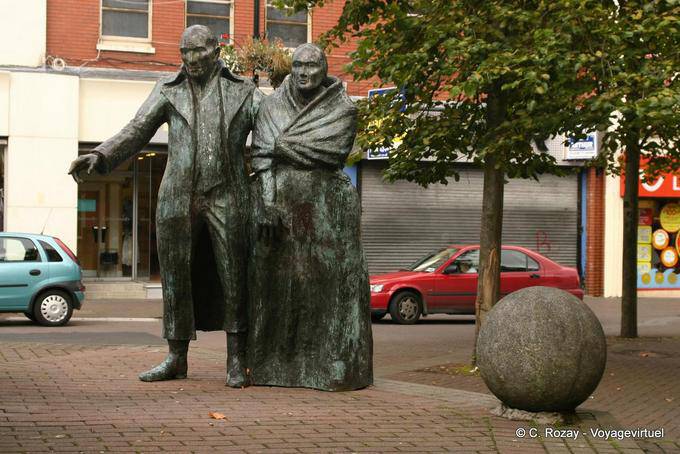 Los emigrantes por Eamonn O'Doherty (1990), Waterloo Place, Derry - Irlanda del Norte