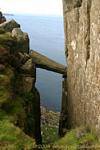 Equilibrar la columna rota en la grieta de la roca, Fairhead, Irlanda del Norte.