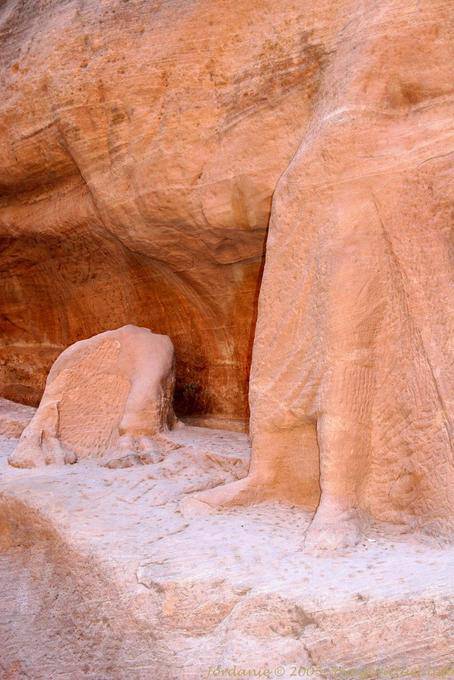 Escultura de un camello vestido con una túnica y Penetrante descalzo en el Siq, Petra - Jordania