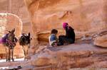 Beduina, sus hijos y sus burros ascienden Deir - Petra, Jordania.