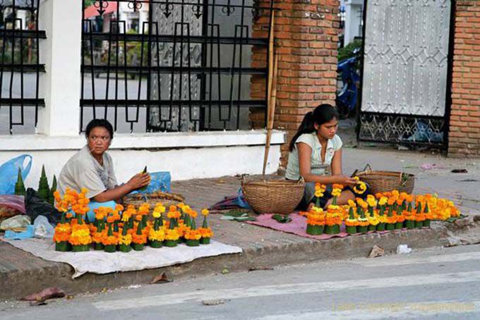 Hacer ofrendas en la acera, de Luang Prabang, Laos
