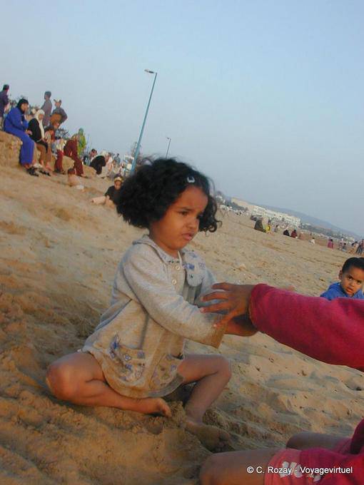 Una niña que juega en la playa Tagharte, Essaouira - Marruecos