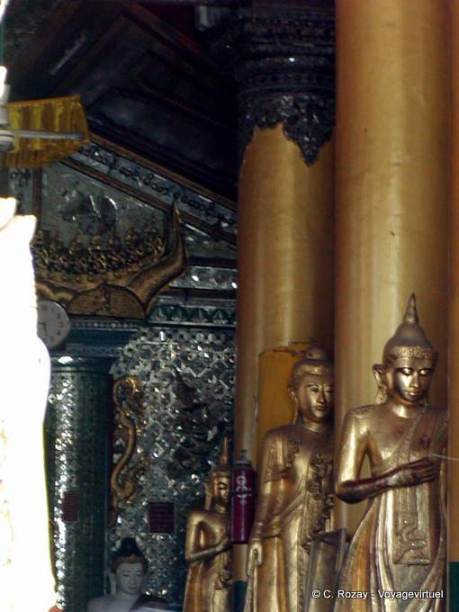 Columnas y de pie Budas en un templo de la pagoda de Shwedagon, Yangon - Myanmar (Birmania)