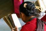 Lectura birmano con un peine en el cabello, el Monte Popa, Birmania.