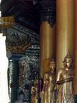 Columnas y de pie Budas en un templo de la pagoda de Shwedagon, Yangon, Birmania.