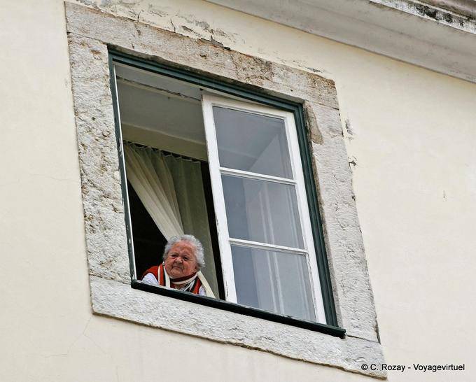 El curioso abuela en su ventana, Alfama, Lisboa - Portugal
