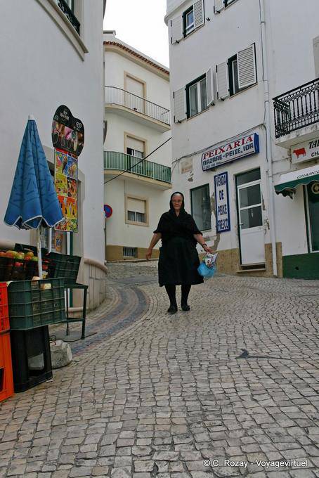 La mujer de negro en la calle empedrada, Nazaré - Portugal