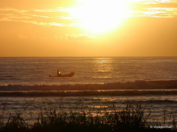 Puesta de sol y barco que cruza a Saint-Leu - Isla de la Reunión