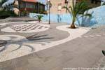Tinnura, Piazza del Sole, el mosaico de mármol blanco de Orosei, casado con gris basalto, Cerdena.