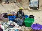 Mujer en cuclillas en medio de cubos multicolores lavandería, Senegal.