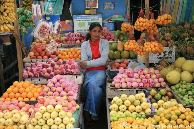 Vendedora entre manzanas y naranjas en el mercado, Nuwara Eliya - Ceilan Sri Lanka