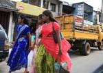 Tres mujeres jóvenes en carreras de vuelta saris, calle Matale, Ceilan Sri Lanka.