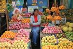 Vendedora entre manzanas y naranjas en el mercado, Nuwara Eliya, Ceilan Sri Lanka.