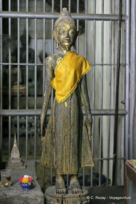 Buda de pie delante de una puerta, Wat Phra que Lampang Luang - Tailandia