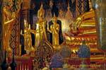 Budas de pie a los pies de Phra Buddha Chinnarat, Wat Phra Si Rattana Mahatha, Phitsanulok, Tailandia.