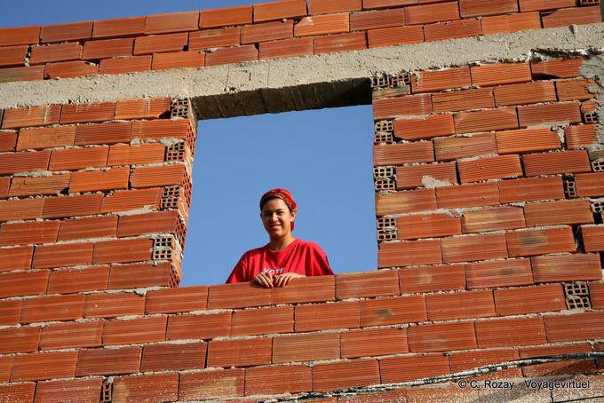 Sonriente mujer desde la ventana de construcción, Mahdia - Túnez