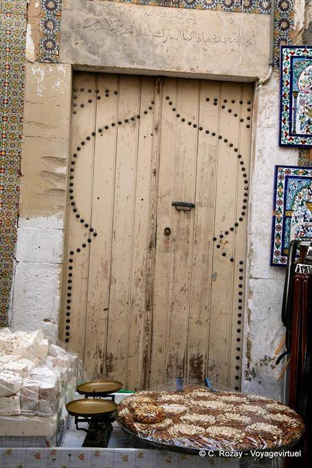 Antigua puerta de madera detrás de una parada del golosinas, Sousse medina - Túnez