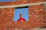 Sonriente mujer desde la ventana de construcción, Mahdia, Túnez.